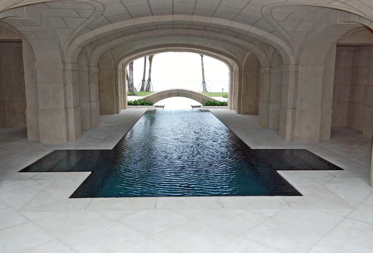 A pool in the middle of an indoor swimming pool.