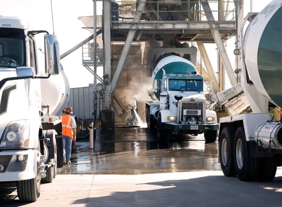 A cement truck is being washed by workers.