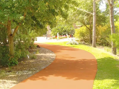 A path in the middle of a park with trees.