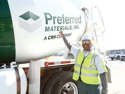 A man standing next to a cement truck.